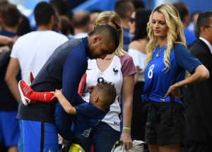 France's forward Dimitri Payet (L) stands next to his wife Ludivine (R) during the Euro 2016 round of 16 football match between France and Republic of Ireland at the Parc Olympique Lyonnais stadium in Decines-Charpieu, near Lyon, on June 26, 2016. / AFP / FRANCK FIFE (Photo credit should read FRANCK FIFE/AFP/Getty Images)